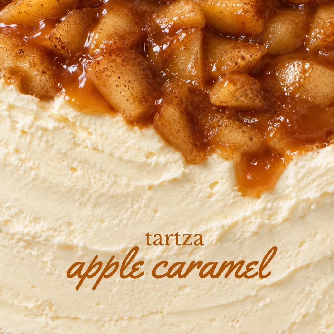 Caramelized apple pieces spilling over a pale, creamy cheesecake surface.