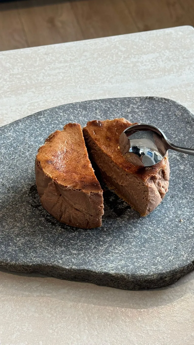 A Nutella tartza cut open on a granite slab, chocolate brown centre, spoon resting on top.