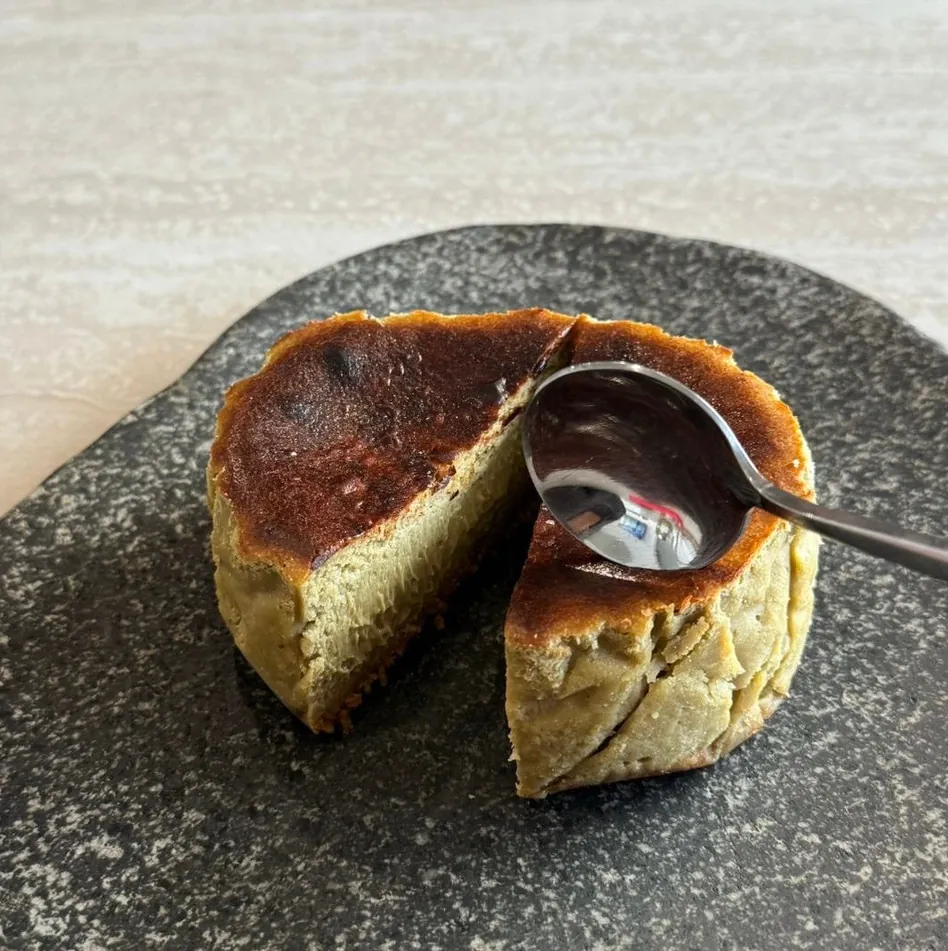 A Pistachio tartza cut open, pale green centre under a dark scorched top.